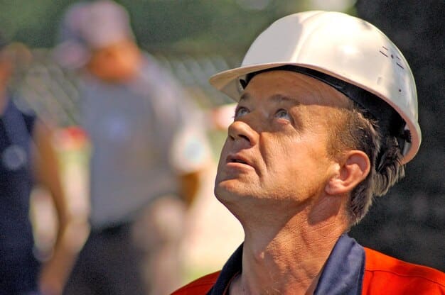A close-up shot of construction workers on a building site, focusing on their activity and the materials they are working with. The image highlights the labor and resources involved in the construction boom.