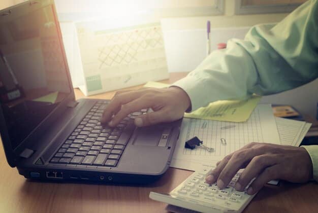 A person using a laptop with the IRS website's withholding estimator tool displayed on the screen, illustrating the process of adjusting tax withholdings.