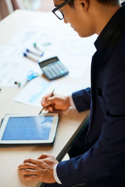 A person reviewing financial data on a tablet, showing the importance of financial planning and management.