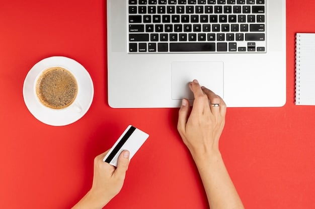 A hand using a credit card to make an online payment. The background showcases a laptop with a secure payment gateway.